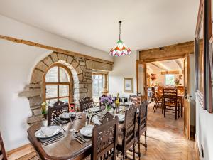 a dining room with a table and chairs and a stone wall at The Barn in Keighley