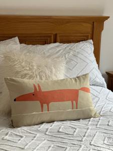 a pillow with a fox on a bed at Y Beudy Bach in Llanfor