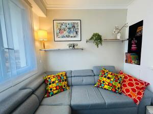 a living room with a gray couch with colorful pillows at Casa Boho in Angers