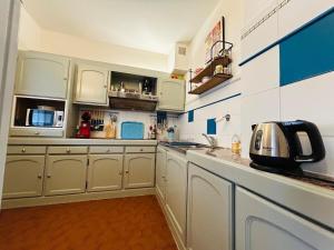 a kitchen with white cabinets and a counter top at Casa Boho in Angers +9 photos