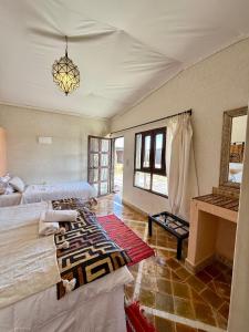 a bedroom with two beds and a chandelier at Royal Sands Camp - Erg Chigaga Luxury Camp in Mhamid +29 photos