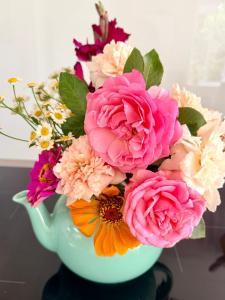 a bouquet of flowers in a green vase at Wyobie Kangaroo Valley Treehouse in Kangaroo Valley