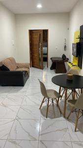 a living room with a table and a couch at Casa Aconchego in Japaratinga