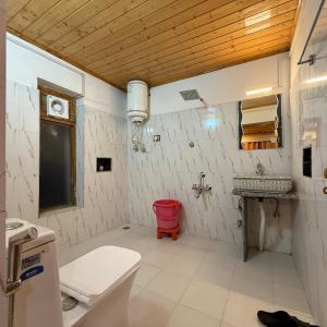a bathroom with a toilet and a sink at The VILLAGE RESORT ASHUNA in Kargil +95 photos