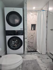 a bathroom with a washing machine and a toilet at Modern & Cozy Suite in Norwood