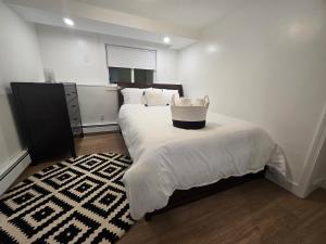 a bedroom with a bed with a basket on it at Modern & Cozy Suite in Norwood