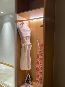 a closet with a white shirt and a dress at One Euphoria Luxe Hotel in Angeles +49 photos
