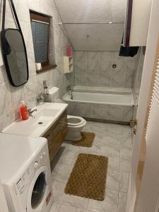 a bathroom with a sink and a washing machine at House in Center in Skopje
