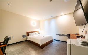 a hotel room with a bed and a kitchen at Daily Motel in Incheon