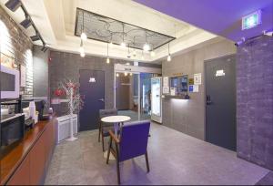 a room with a table and chairs and a kitchen at Daily Motel in Incheon