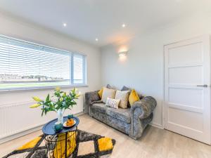 a living room with a couch and a window at River View Cottage in Berwick-Upon-Tweed