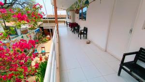 a balcony with tables and chairs and pink flowers at frente al mar Hotel La Morena in Taganga +1 photo