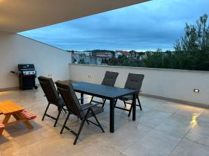 a table and chairs on a patio with a view at Marepromo Jezera 1 in Jezera +8 photos