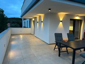 a patio with a wooden table and chairs on a balcony at Marepromo Jezera 1 in Jezera