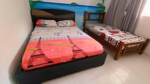 a bedroom with two beds with the eiffel tower at frente al mar Hotel La Morena in Taganga