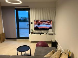 a living room with a couch and a tv on the wall at Marepromo Jezera 1 in Jezera