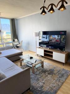 a living room with a large flat screen tv at Cozy Apartment with Table Mountain and beach views in Cape Town