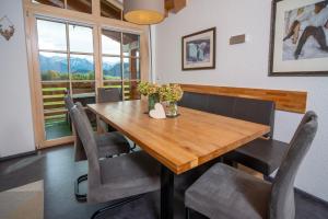 a dining room with a wooden table and chairs at Traumferienwohnung Alpenliebe Sommer-Hörnerbahnen kostenlos in Bolsterlang +31 photos