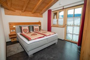 a bedroom with a bed in a room with windows at Traumferienwohnung Alpenliebe Sommer-Hörnerbahnen kostenlos in Bolsterlang