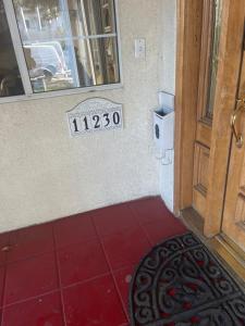 a door with a sign next to a red floor at Sam property in Los Angeles