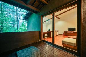 a room with a large window and a bed and a desk at Oita Kuoritei in Kokonoe