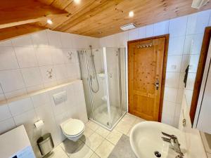 a bathroom with a shower and a toilet and a sink at Ferienhaus Alpenherz Sommer-Bergbahnen-kostenlos in Bolsterlang +19 photos