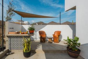 a patio with chairs and a table on a white wall at Olivo in San Carlos