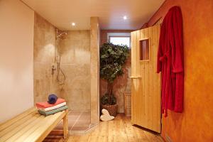 a bathroom with a shower and a bench in front of a door at Ferienhaus ALPVERLIEBT Sommer-Hörnerbahnen kostenlos in Bolsterlang +23 photos