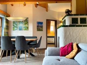 a living room with a couch and a table and chairs at Ferienhaus ALPVERLIEBT Sommer-Hörnerbahnen kostenlos in Bolsterlang