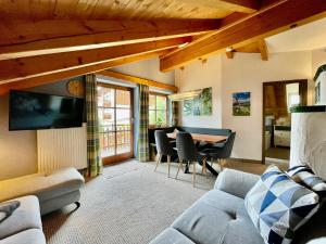 a living room with a couch and a table at Ferienhaus ALPVERLIEBT Sommer-Hörnerbahnen kostenlos in Bolsterlang