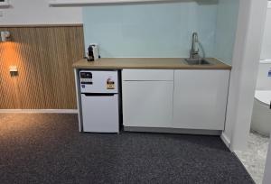 a kitchen with a counter with a sink and a refrigerator at The Highlander Motel - 24HR Check In in Maryborough +29 photos
