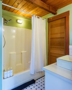 a bathroom with a shower and a white shower curtain at Private Pond, Dog-Friendly, Peaceful, Golfing in Eastsound +48 photos
