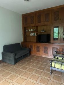a living room with a couch and a tv at Chácara sol nascente in Suzano