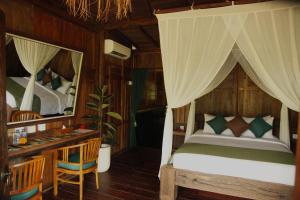 a bedroom with a bed and a desk and a mirror at Ardan Maison The Garden Villas in Ubud