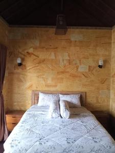 a bed with two pillows on top of it at Homestay Mroom Bali in Perean