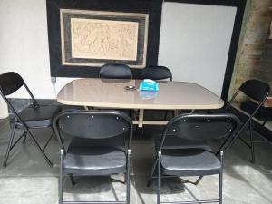 a table and four chairs in a room at Homestay Mroom Bali in Perean