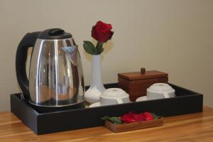 a tea kettle and a vase with a red rose at Selau Asry in Sidemen