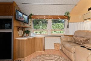 a living room with a couch and a tv in an rv at Airstream in Art's District in Asheville