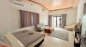 a bedroom with a bed and a couch and a chair at Light Star Villa in Kuta Lombok
