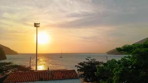 a sunset over the ocean with boats in the water at frente al mar Hotel La Morena in Taganga