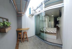a room with a balcony with a bed and a stool at Blessed Homes in Braço do Norte