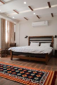 a bedroom with a bed and a rug at Mabiti hotel in Al-ʿUla