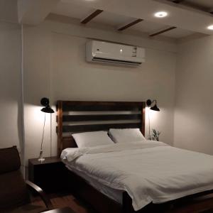 a bedroom with a bed and a air conditioner at Mabiti hotel in Al-ʿUla +1 photo