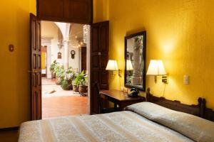 a yellow room with a bed and a mirror at Hotel Posada San Agustin in Durango +26 photos