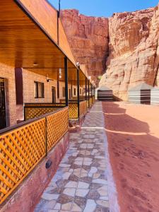 a building with a walkway next to a cliff at Naif Bedouin tour in Wadi Rum