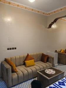 a living room with a couch and a table at Casa Ayour in Merzouga