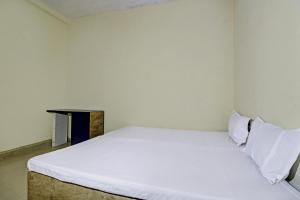 a white bed in a room with a table at SPOT ON HOTEL MOONLIGHT in Bhilai +19 photos