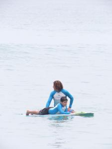 a woman and a child on a surfboard in the water at Leal Surf School in Rio de Janeiro +38 photos