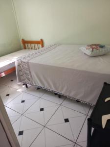 a bedroom with a bed and a tiled floor at Lar da Dona Judite in Pontal do Paraná