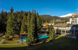 een luchtzicht op een huis met een zwembad en bomen bij Laax Rancho Studio Apartment in Laax